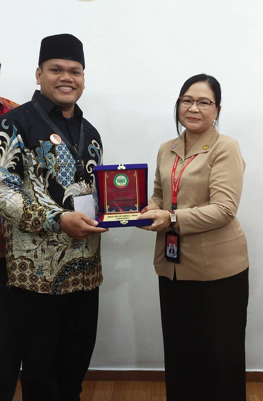Dr. Jupriaman, S.Pd., M.Hum menyerahkan Plakat STITA Labuhanbatu kepada Ibu Kepala Sekolah SIKL (Sekolah Indonesia Kuala Lumpur) Malaysia ibu Friny Napasti, S.Pd.,M.Pd.